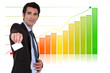 Businessman with calling card standing by bar chart