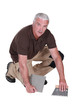 Man cementing tile to floor