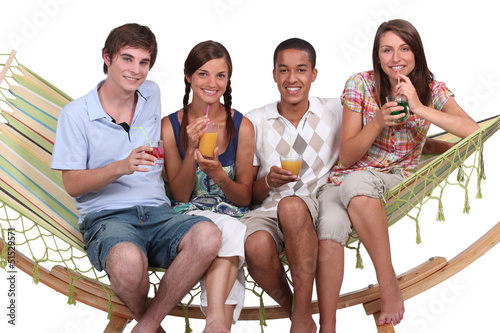 Photo: Friends drinking cocktails on a hammock Friends drinking cocktails on a hammock