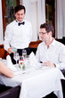 Kellner schenkt Wasser ein Dinner Restaurant