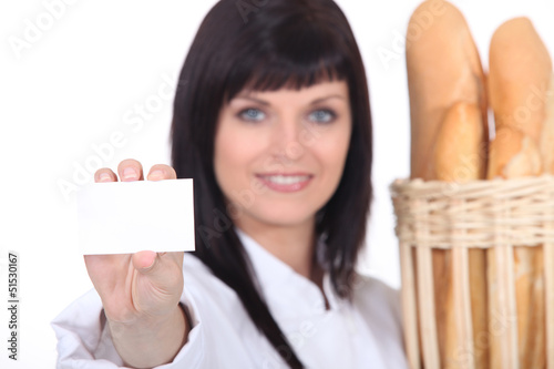 Photo: Female baker showing businesscard Female baker showing businesscard