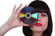 Photo: Woman holding a cd to an her eye Woman holding a cd to an her eye