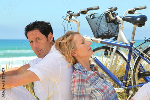 Photo: couple with bikes on the beach couple with bikes on the beach
