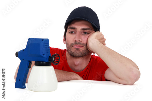 Photo: A painter looking a his spray gun. A painter looking a his spray gun.