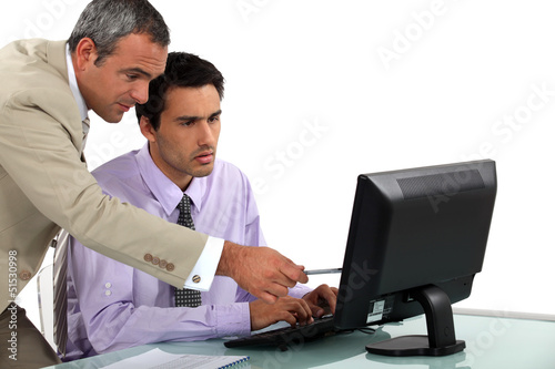 Photo: Man pointing out an error to his colleague Man pointing out an error to his colleague