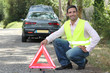 Photo: Man putting out a hazard triangle Man putting out a hazard triangle
