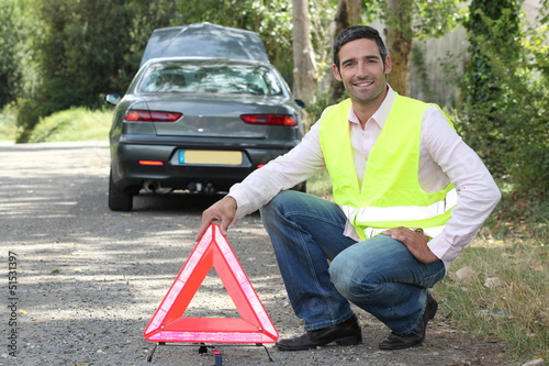 Photo: Man putting out a hazard triangle Man putting out a hazard triangle