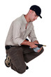 A manual worker examining a welding torch.