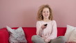 Young smiling woman with remote control, tracking shot