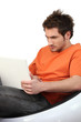 Frowning man using his laptop