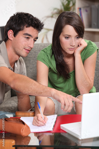 Photo: couple looking at laptop and taking notes couple looking at laptop and taking notes