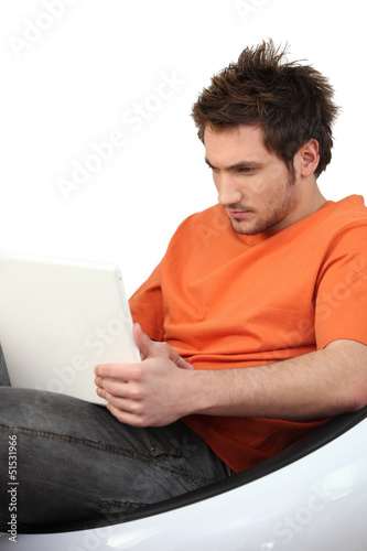 Photo: Frowning man using his laptop Frowning man using his laptop