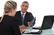 smiling mature businessman and young blonde assistant