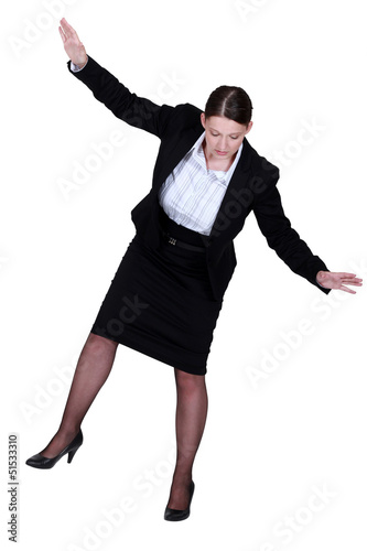 Photo: female businesswoman miming tightrope walker female businesswoman miming tightrope walker