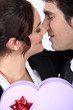 Man offering girlfriend heart-shaped box of chocolates