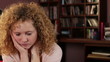 Young sad woman sitting in the room, tracking shot