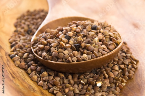 Photo: Buckwheat seeds on wooden spoon in closeup Buckwheat seeds on wooden spoon in closeup