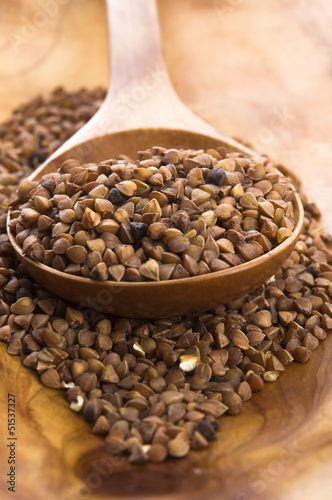 Photo: Buckwheat seeds on wooden spoon in closeup Buckwheat seeds on wooden spoon in closeup