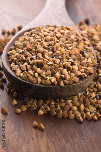 Photo: Buckwheat seeds on wooden spoon in closeup Buckwheat seeds on wooden spoon in closeup
