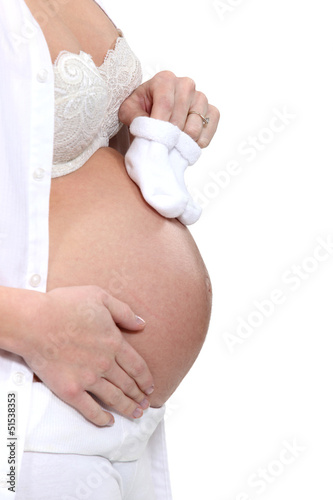 Photo: Pregnant woman holding baby shoes Pregnant woman holding baby shoes