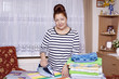 Elderly woman ironing towels at home