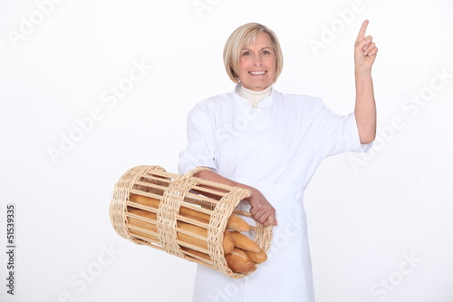 Photo: a mature female baker showing something a mature female baker showing something