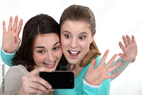 Photo: Two girls posing with camera phone Two girls posing with camera phone