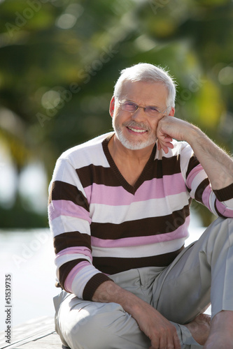 Photo: Elderly man sat in garden Elderly man sat in garden