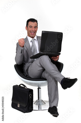 Photo: Successful man sat in chair with laptop Successful man sat in chair with laptop