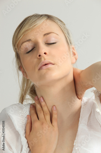 Photo: Blond woman suffering from neck pain Blond woman suffering from neck pain
