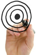 Male hand drawing target on white board