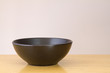 Black bowl on wooden table