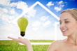 Young woman looking at green light bulb