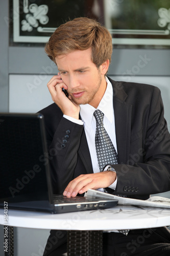 Photo: Young contractor with laptop and cell phone Young contractor with laptop and cell phone