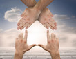 Hands crossed representing a house with blue sky