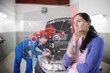 Auto mechanic with customer looking at futuristic interface
