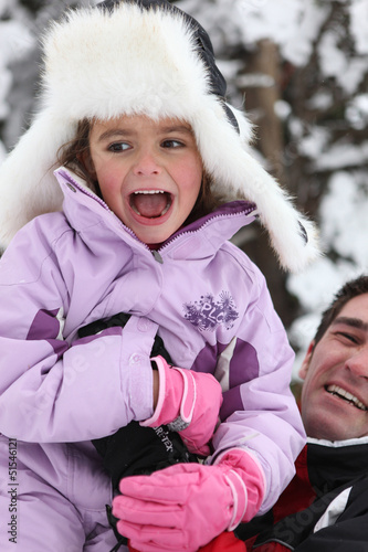 Photo: Father and daughter having fun in the snow Father and daughter having fun in the snow