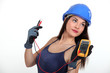 Sexy tradeswoman holding a multimeter