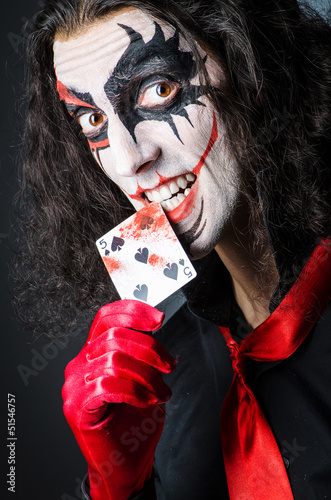 Photo: Evil clown with cards in dark room Evil clown with cards in dark room