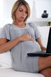 Pregnant woman looking at a laptop