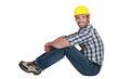 A handsome manual worker seated.