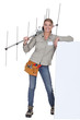Foto: Woman with an aerial leaning against a blank poster Woman with an aerial leaning against a blank poster
