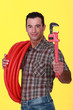 craftsman holding a spanner and a pipe hose