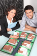 Photo: Agent and client looking at a housing model Agent and client looking at a housing model