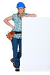 Female builder stood with advertising panel