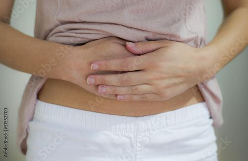 Photo: woman with hand on stomach woman with hand on stomach