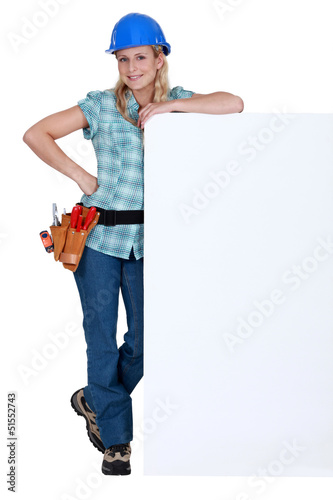 Photo: Female builder stood with advertising panel Female builder stood with advertising panel
