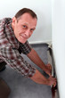 Foto: Man adjusting carpet Man adjusting carpet