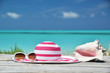 Sunglasses, hat and shell against ocean. Exuma, Bahamas