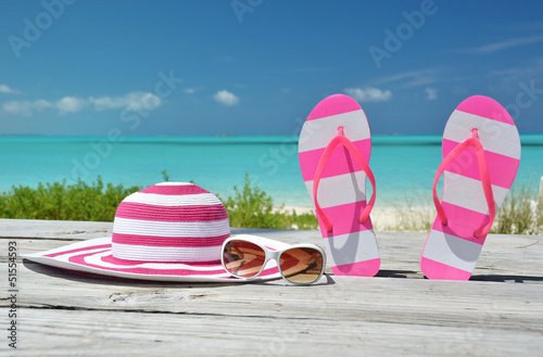 Photo: Hat, sunglasses and flip-flops against ocean. Exuma, Bahamas Hat, sunglasses and flip-flops against ocean. Exuma, Bahamas